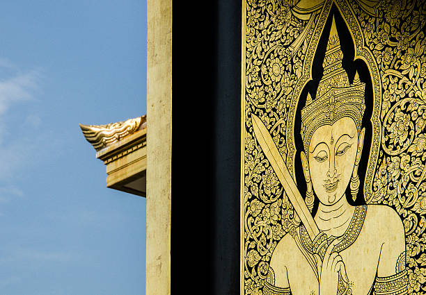 Wat Traimit Golden Engravement with Blue Sky Background Engraved historical artwork of buddha near the open window and blue skies engravement stock pictures, royalty-free photos & images