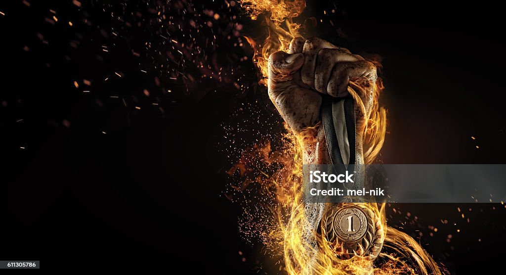 Sport. Winner in a competition. Fire and energy Man's hand holding up trophy medal Winning Stock Photo