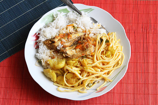 Bowl of chicken and vegetables with rice, noodles and olluco.