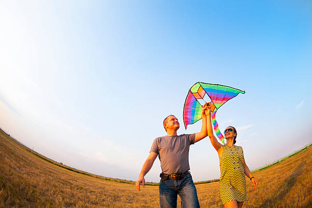 istock Happy couple in love with flying a kite 611307462