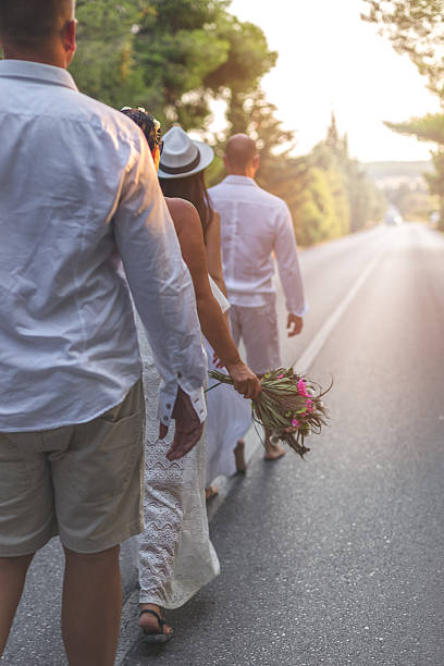istock two couples grupe wedding walking on the road 611309228