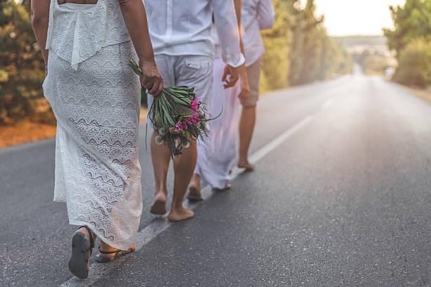 istock two couples grupe wedding walking on the road 611309230