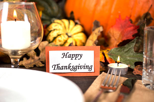 istock Happy Thanksgiving place setting with autumn centerpiece on table. 611310540