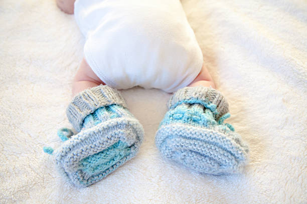 istock Tiny Baby Feet In Handmade Shoes 611314970