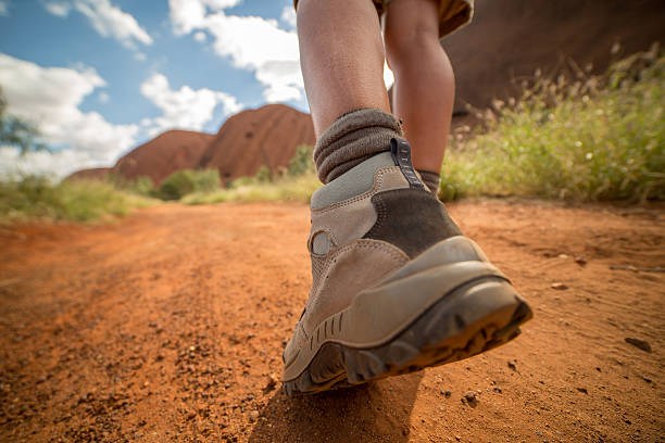 istock Low angle view of hiker's boots walking on dirt road 611316244