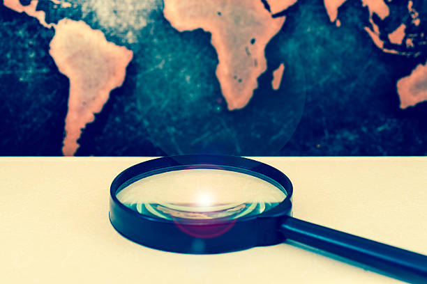 istock Magnifying lens against grunge world map, with lens flare 611316338
