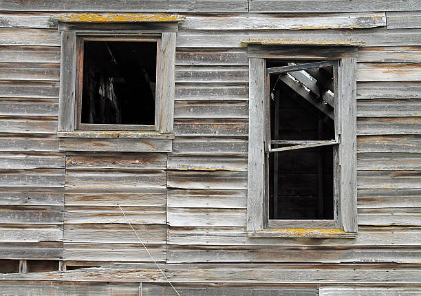 istock Two Broken Windows in a Dilapidated Brown Wooden House 611317000