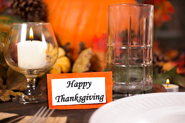 istock Happy Thanksgiving place setting with autumn centerpiece on table. 611318028