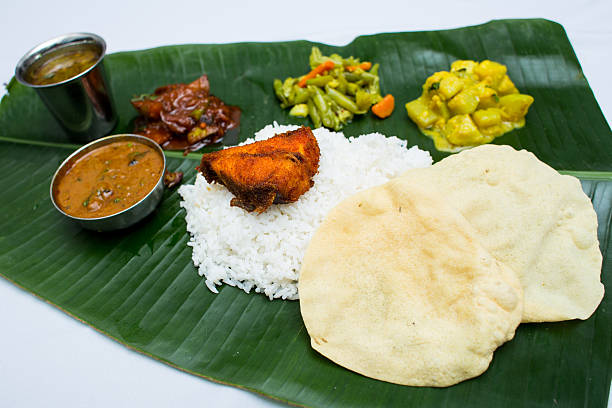 istock Indian meal with fish and plain rice on banana leaf 611318782