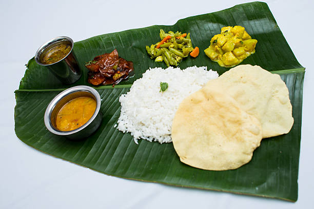 istock Indian vegetarian food with plain rice on banana leaf tray 611318848