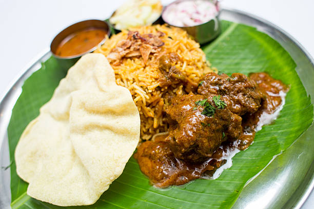 istock Indian meal with mutton and fried rice on banana leaf 611318870