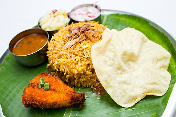 istock Indian meal with fish and fried rice on banana leaf 611318990