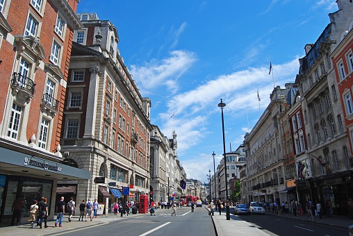 London, United Kingdom - July 7, 2014. View of Piccadilly street in London, with historic buildings, commercial properties, street traffic and people.