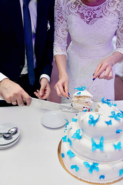 istock Beauty bride and handsome groom are cutting a wedding cake 611323596