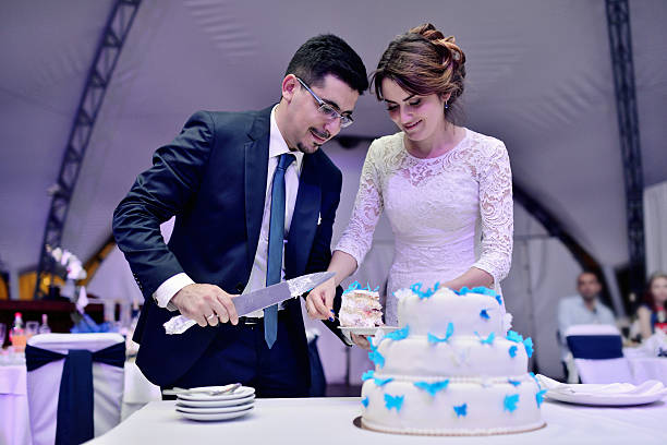 istock Beauty bride and handsome groom are cutting a wedding cake 611323716