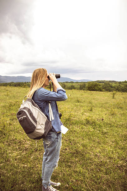 istock Woman looking though binoculars at mountain 611325738