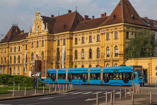 Zagreb, Croatia - August 17, 2016: A view of the Museum of Arts and Crafts and a common blue tram in Zagreb during the day.