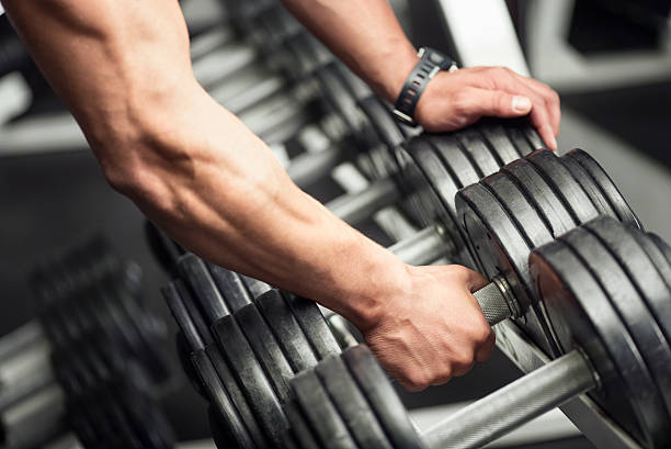 istock Strong well built bodybuilder lifting a dumbbell 611329260