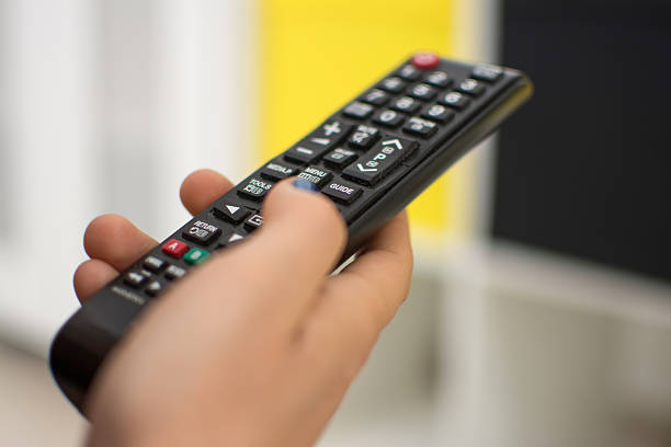 istock Close up of a hand holding a television remote control. 611329700