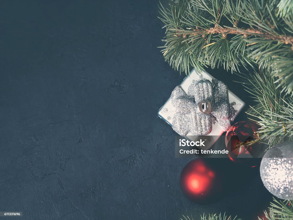 Blue spruce tree branches with Christmas decorations Blue spruce branches with christmas baubles on dark black background. Copy space. Toned image Backgrounds Stock Photo