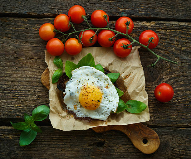 istock Scrambled eggs on toasted bread with basil, spices and tomatoes 611332276