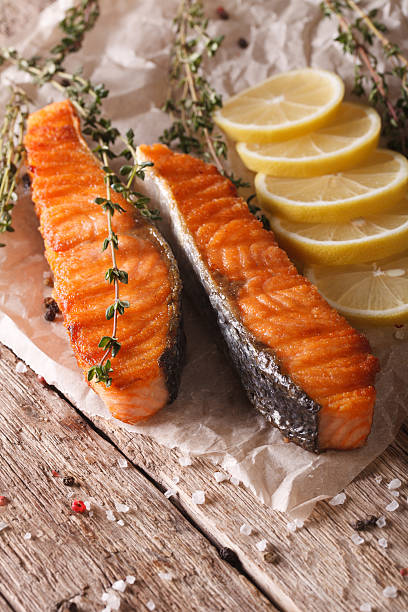 istock Grilled salmon with lemon and thyme on a paper close-up 611332766