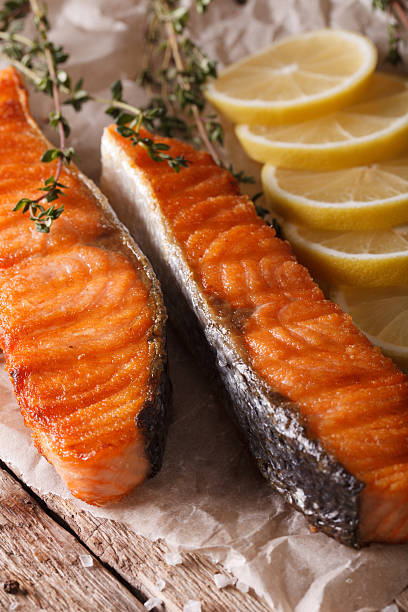 istock Grilled salmon with lemon macro on paper. vertical 611333074