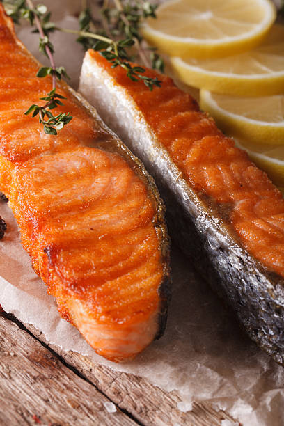 istock Delicious food: grilled salmon with lemon on the paper macro 611333574