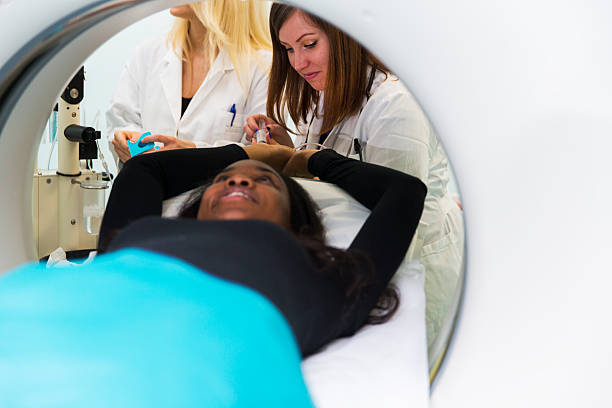 istock Young black woman waiting for CAT scan with contrast 611334690