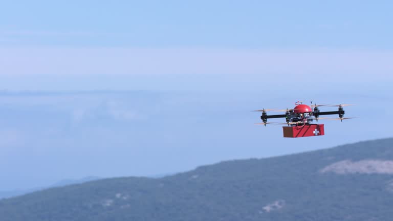 Slow motion medium handheld shot of a drone delivering a first aid kit box across the sky above the hills. Shot in Croatia.