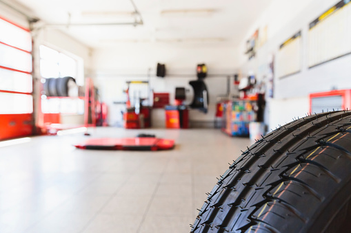 Defocused view into the auto repair shop with a tire in front