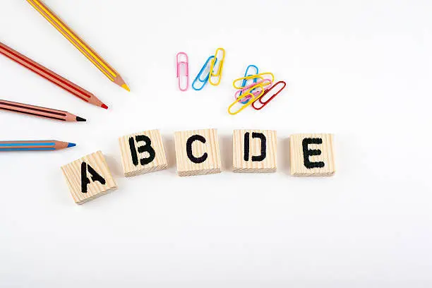 Photo of abcde from wooden letterson on white office desk