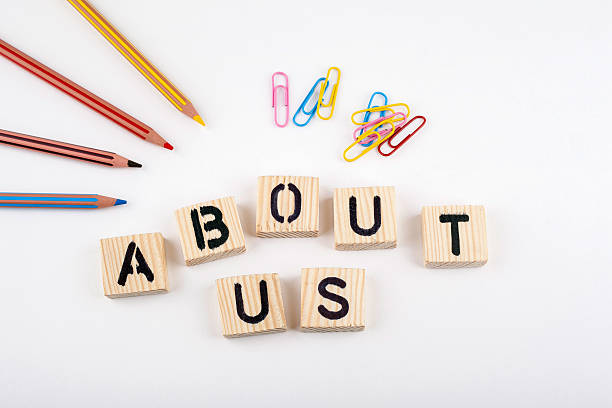istock Text: About Us from wooden letterson on white office desk 611590328