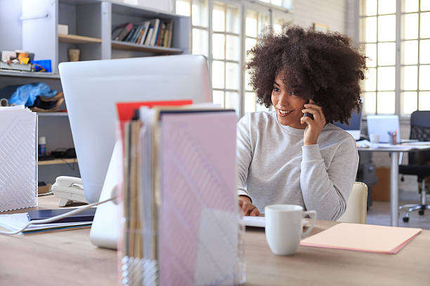 istock Young female assistant talking on smart phone at workplace 611590926