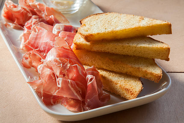 istock Crudo ham and slices of bread on a plate 611591734