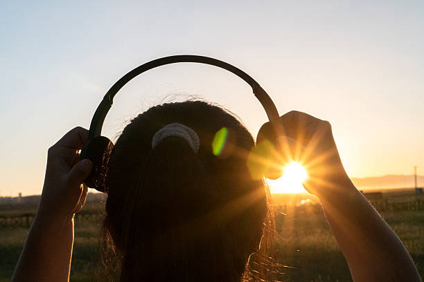 istock wearing earphone on head at sunset 611593834