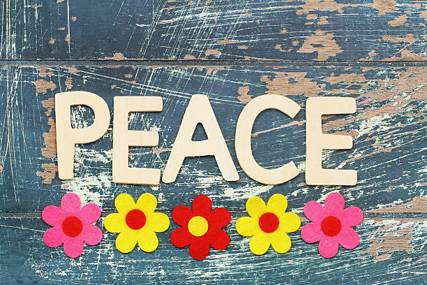 istock Peace written with wooden letters on rustic surface, colorful flowers 611596308