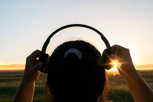 istock wearing earphone on head at sunset 611597196
