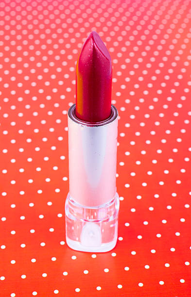istock Red lipstick on a red background with dots 611597980