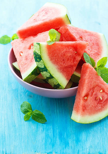 istock Triangular slices of fresh watermelon on blue wooden background 611598106