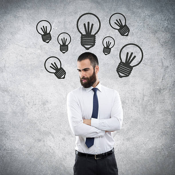 istock Businessman thinking and light bulbs drawn over his head 611600378