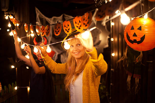 istock Mom and daughter decorate for Halloween 611600414