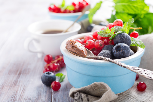 Delicious chocolate dessert with berries and mint served in ramekin. Copy space