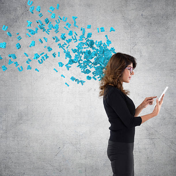 istock Businesswoman using digital tablet with flying alphabets 611601600