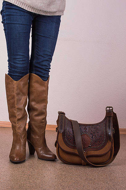 istock Women's long legs in jeans and high boots 611602046