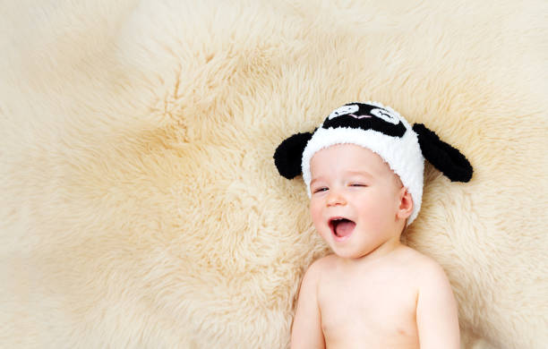istock one year old baby lying in sheep hat on lamb 611602950