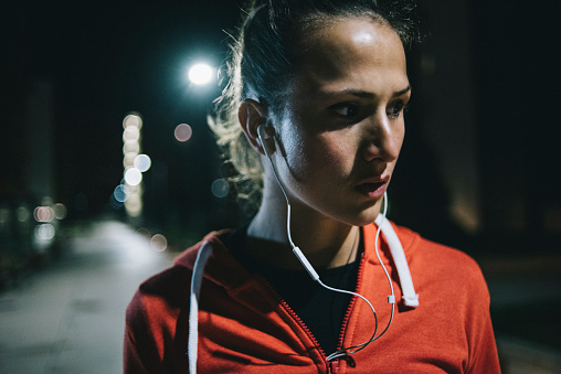 Young female athlete preparing for midnight workout in park