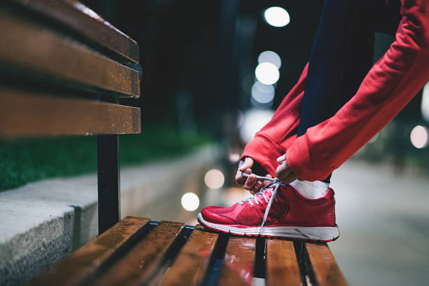 młody sportowiec przygotowujący się do długich ćwiczeń - shoe tying adult jogging zdjęcia i obrazy z banku zdjęć
