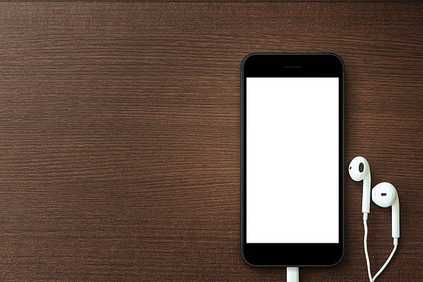 istock phone blank screen and headphone on wood table 611606246