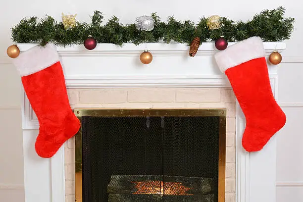 closeup santa stockings on fireplace with garland 